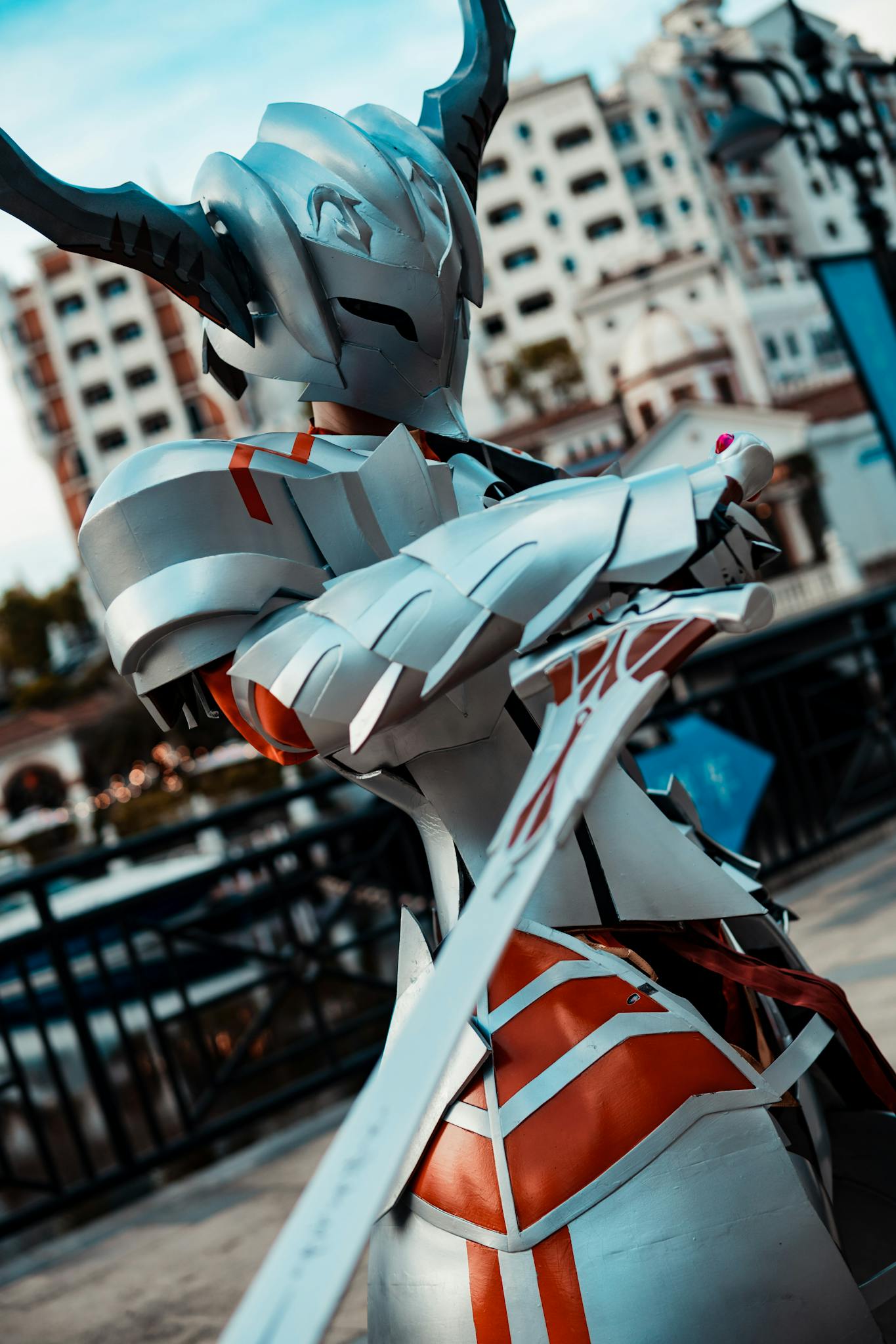 Cosplayer in futuristic armor poses on an urban street during the day.